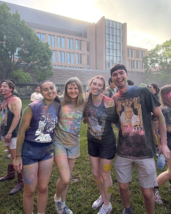 people covered in colored powders together 