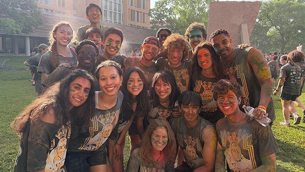 huddled people smeared in colored powder