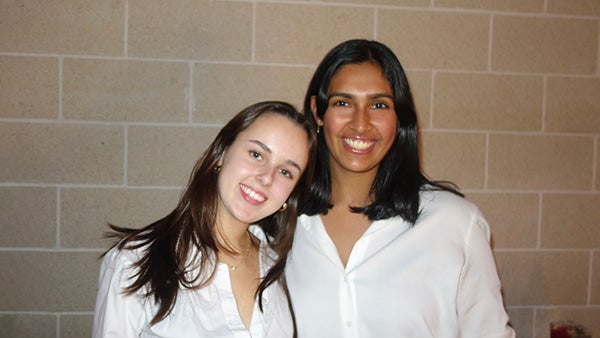 two girls, one resting her head on the other's shoulder