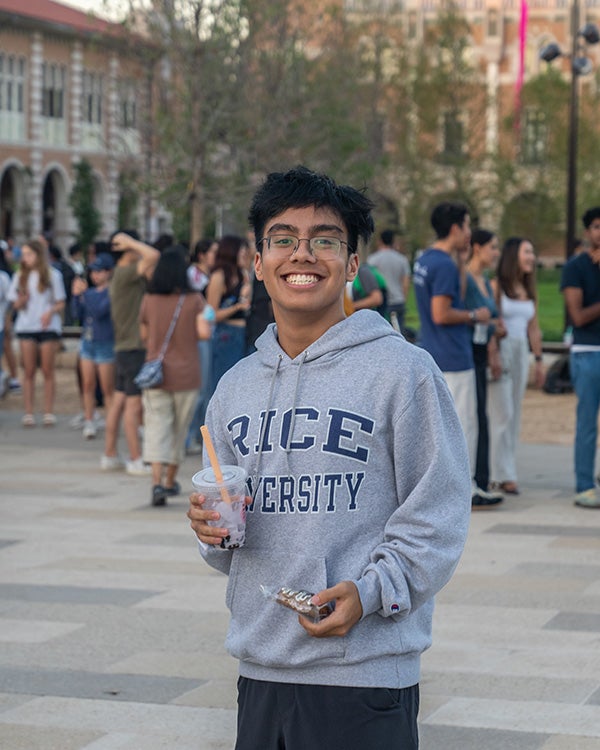 A male student wearing a gray Rice University branded sweatshirt