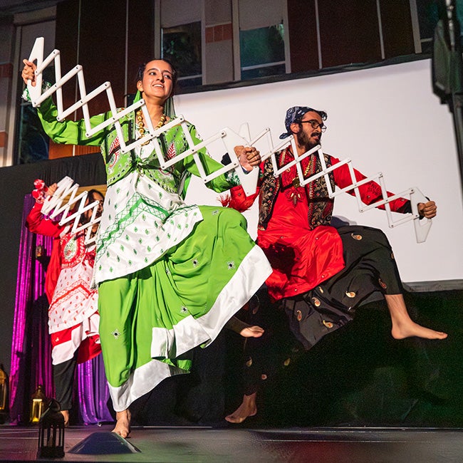 Two people dancing, holding accordion shaped props