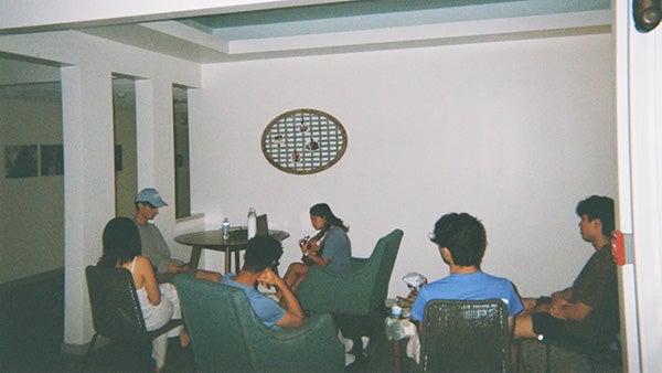 People sitting on chairs in dimly lit room