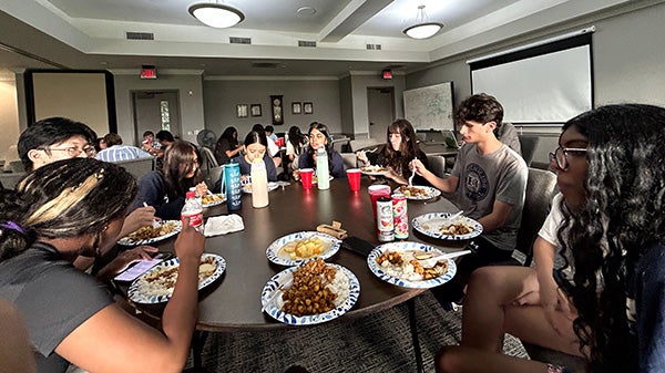 People sitting around a circular table eating food