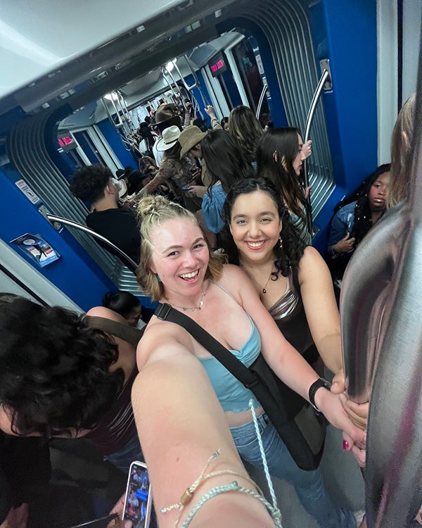 Two girls taking a 0.5 selfie in a crowded train