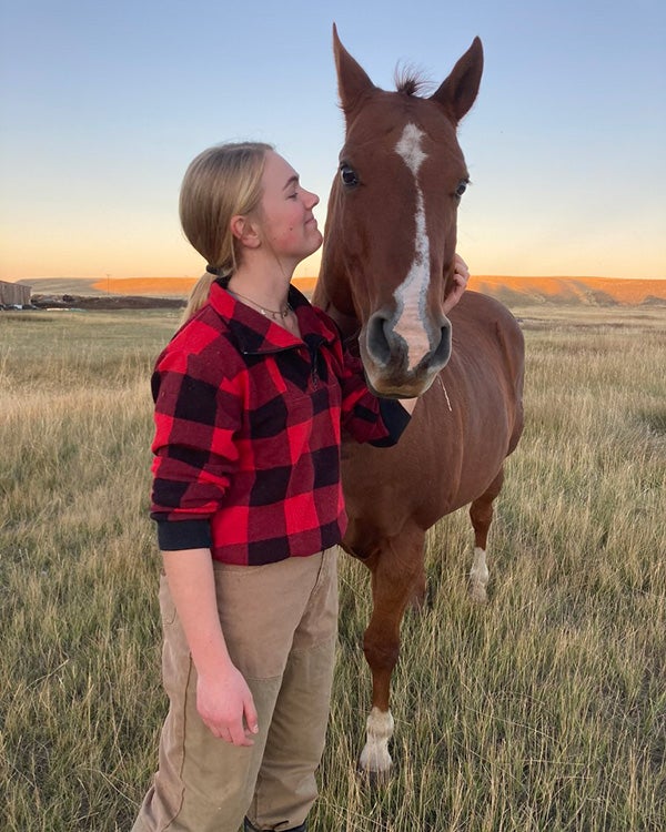 Girl standing next to a horse