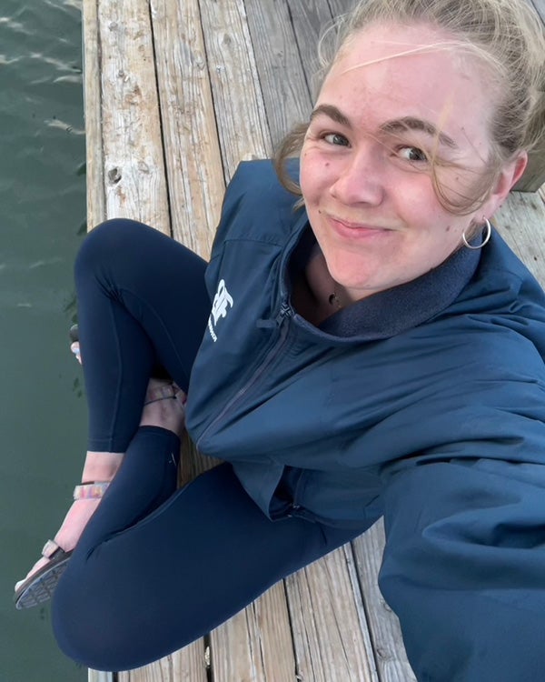 Arial view of a girl sitting on a boardwalk over the water 