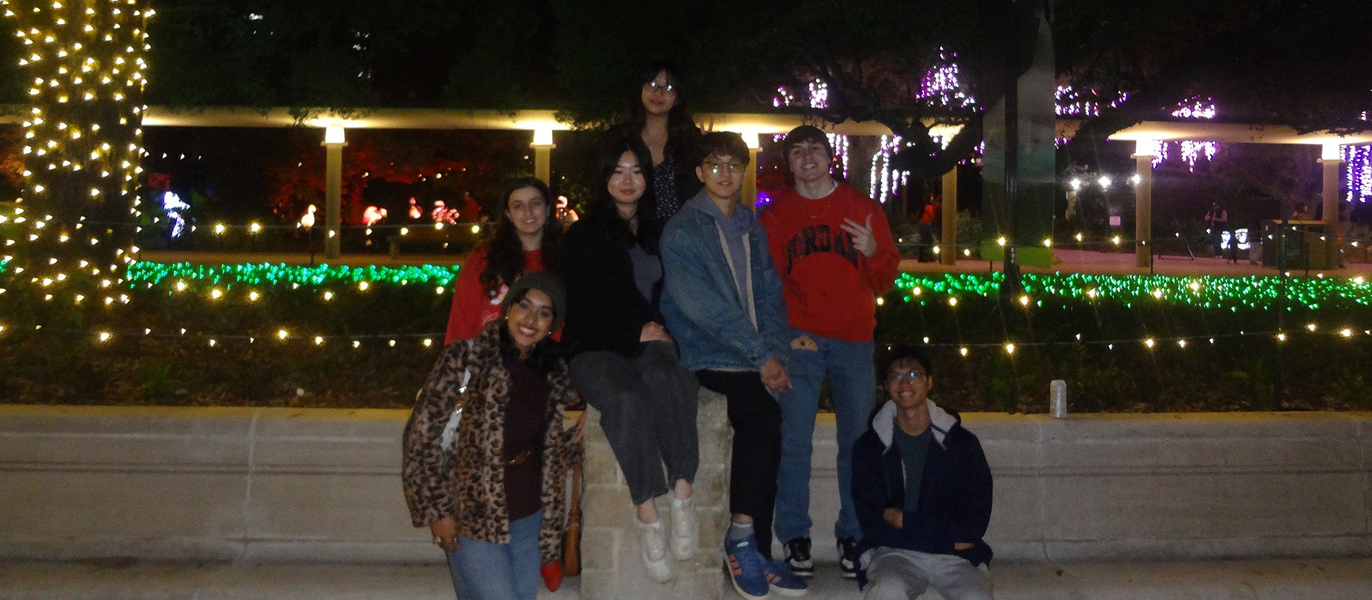 Six people taking a group photo together in the nighttime
