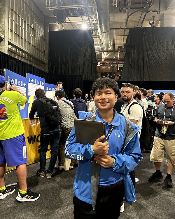 A guy holding a folder in a crowded backstage area