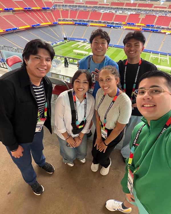 .5 angle selfie of six students inside a soccer stadium