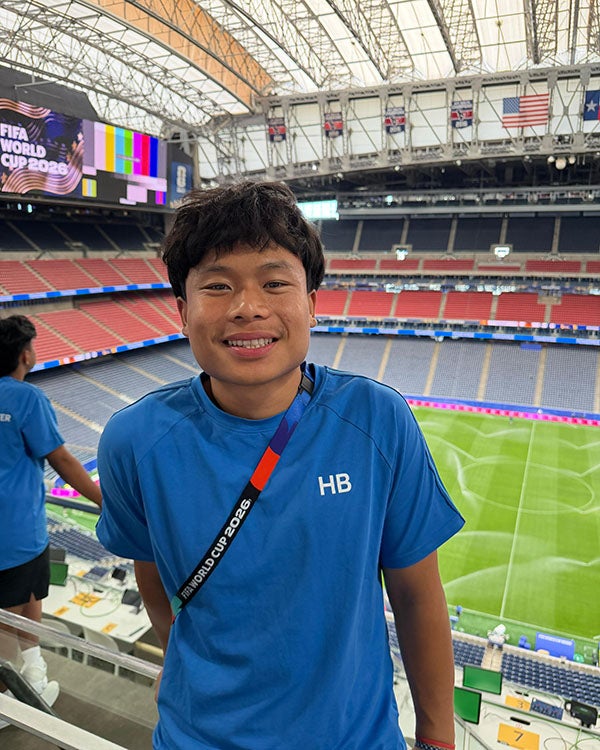 A guy standing in front of a huge soccer stadium