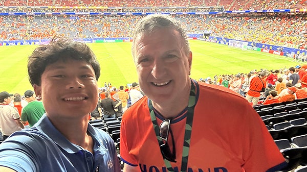 A selfie of a young guy with an older man at a soccer game