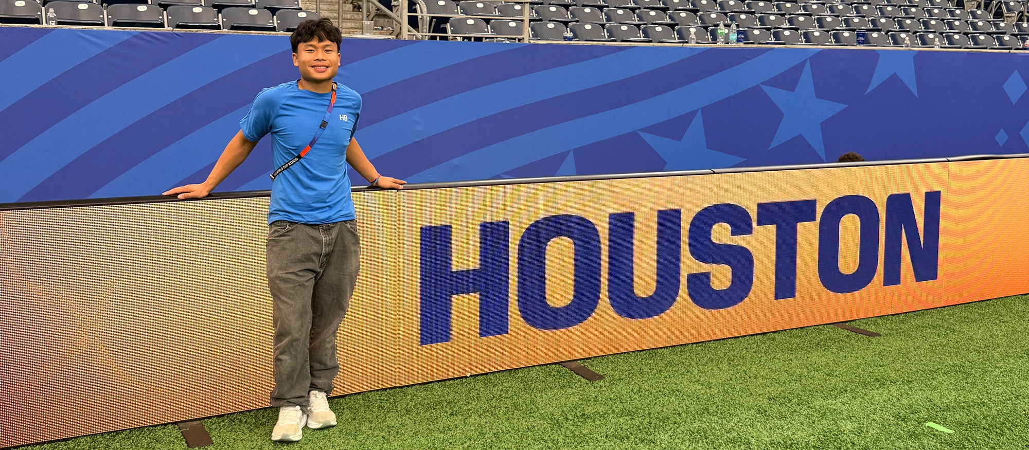 A guy standing in front of a large sign that says "Houston"