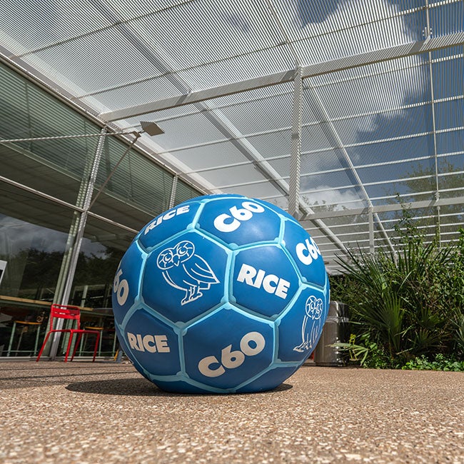 A blue soccer ball with writing on it, sitting on a cobblestone pathway