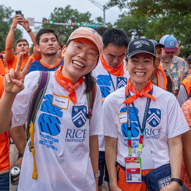 Two people in white shirts with the Rice crest and the FIFA World Cup 2026 logo posing for the camera