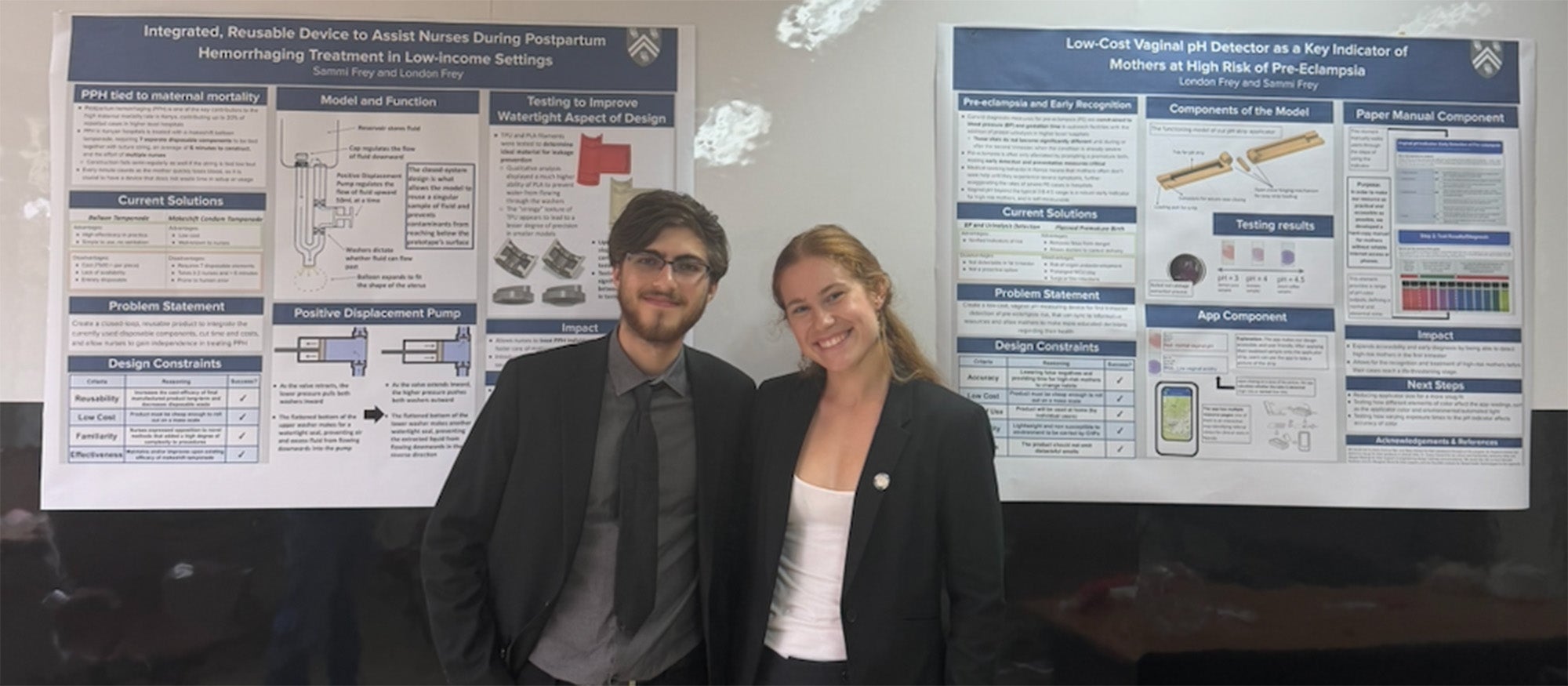 Two people standing together in front of two research posters on a wall