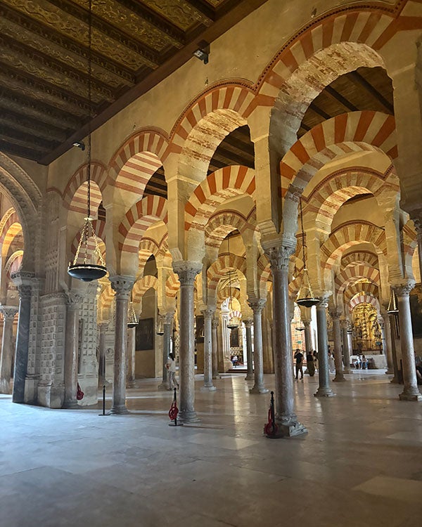 Arched doorways leading into a hall filled with more arched pillars