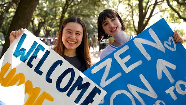 Two people holding painted signs