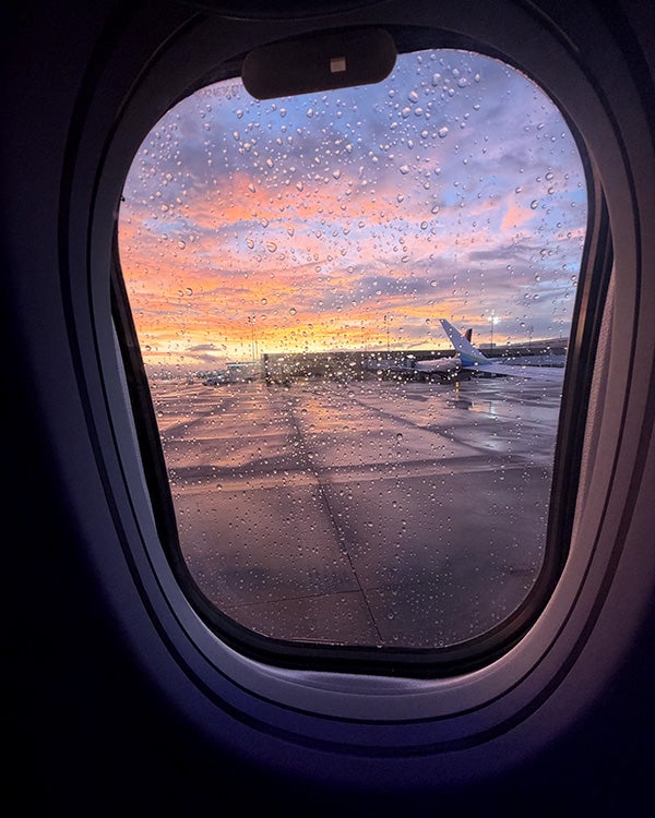 A vividly-colored sunset sky visible out of a plane window