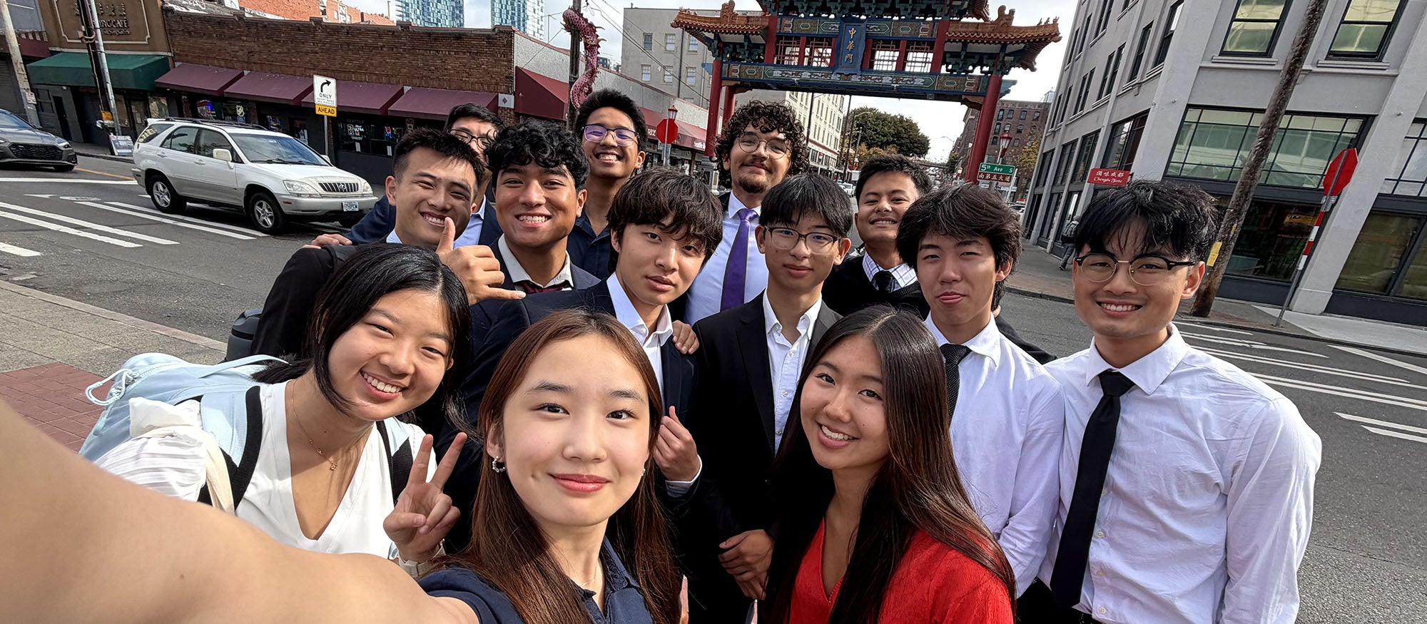 Group of people take a selfie outside of a Chinese architecture gate