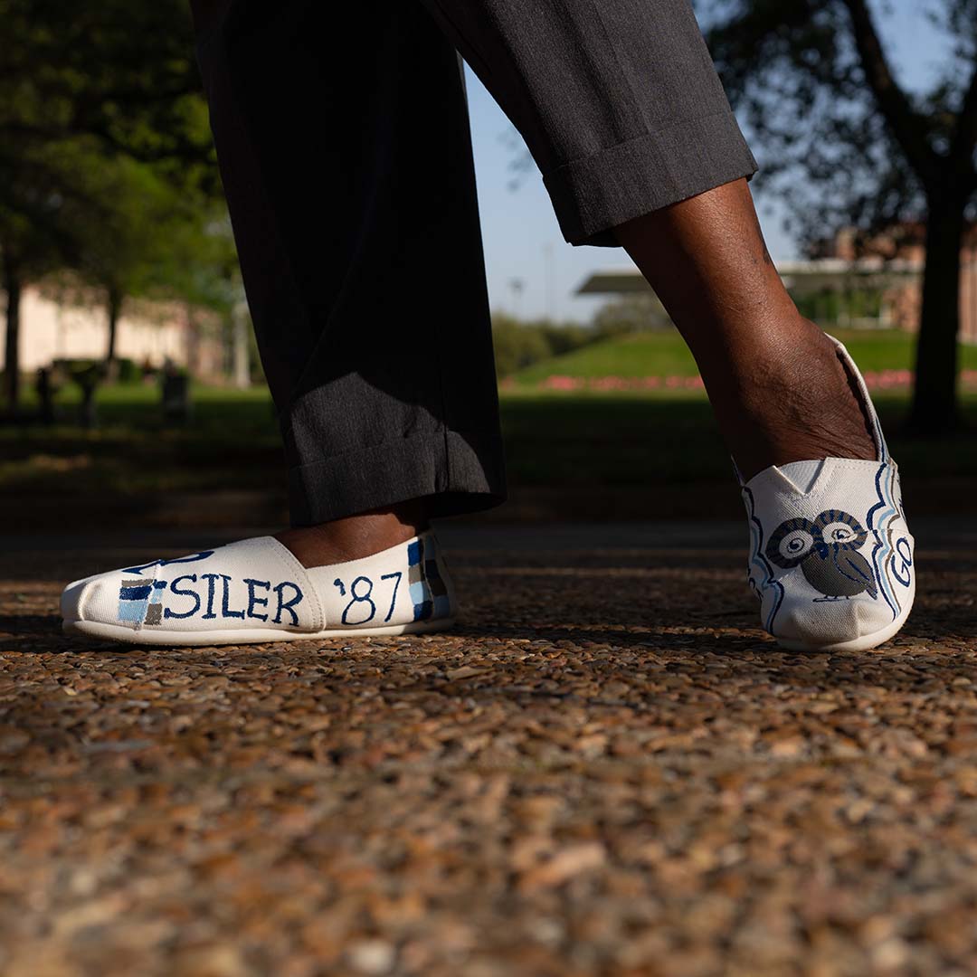 A close up picture of canvas shoes worn by an alumna, Tamara Siler, that are decorated with her graduation year and other Rice iconography.