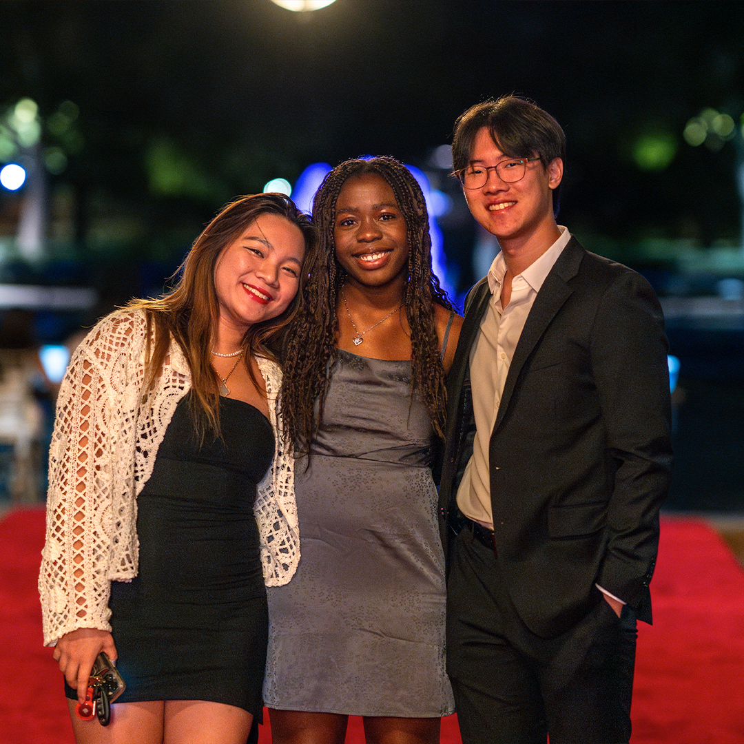 Trio of students on red carpet entering the Esperanza dance