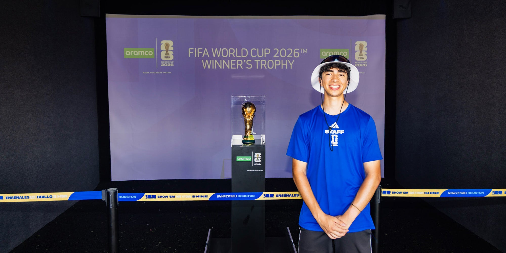 A guy standing in front of a World Cup trophy