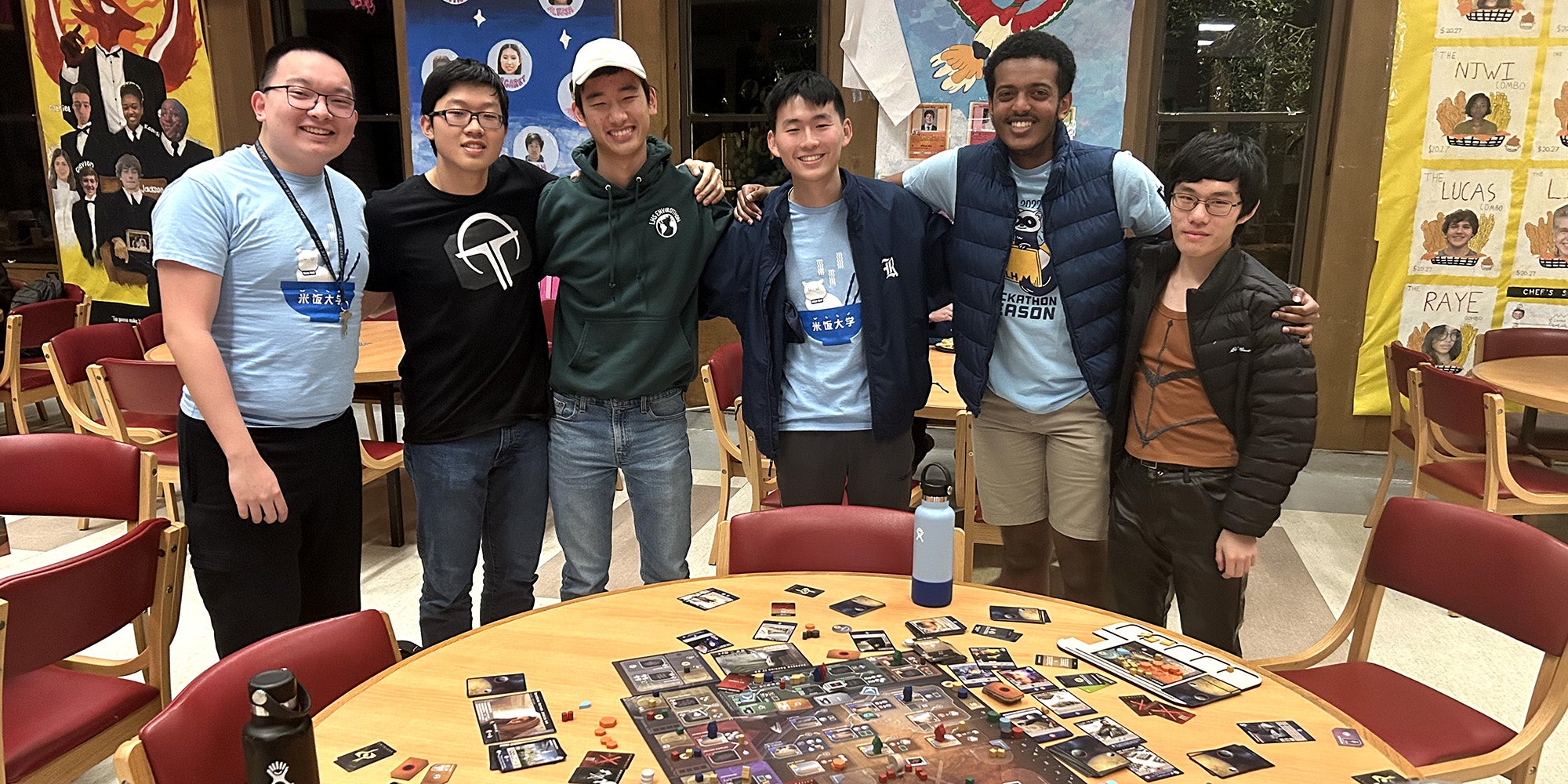 Boys standing behind a round table with cards on it