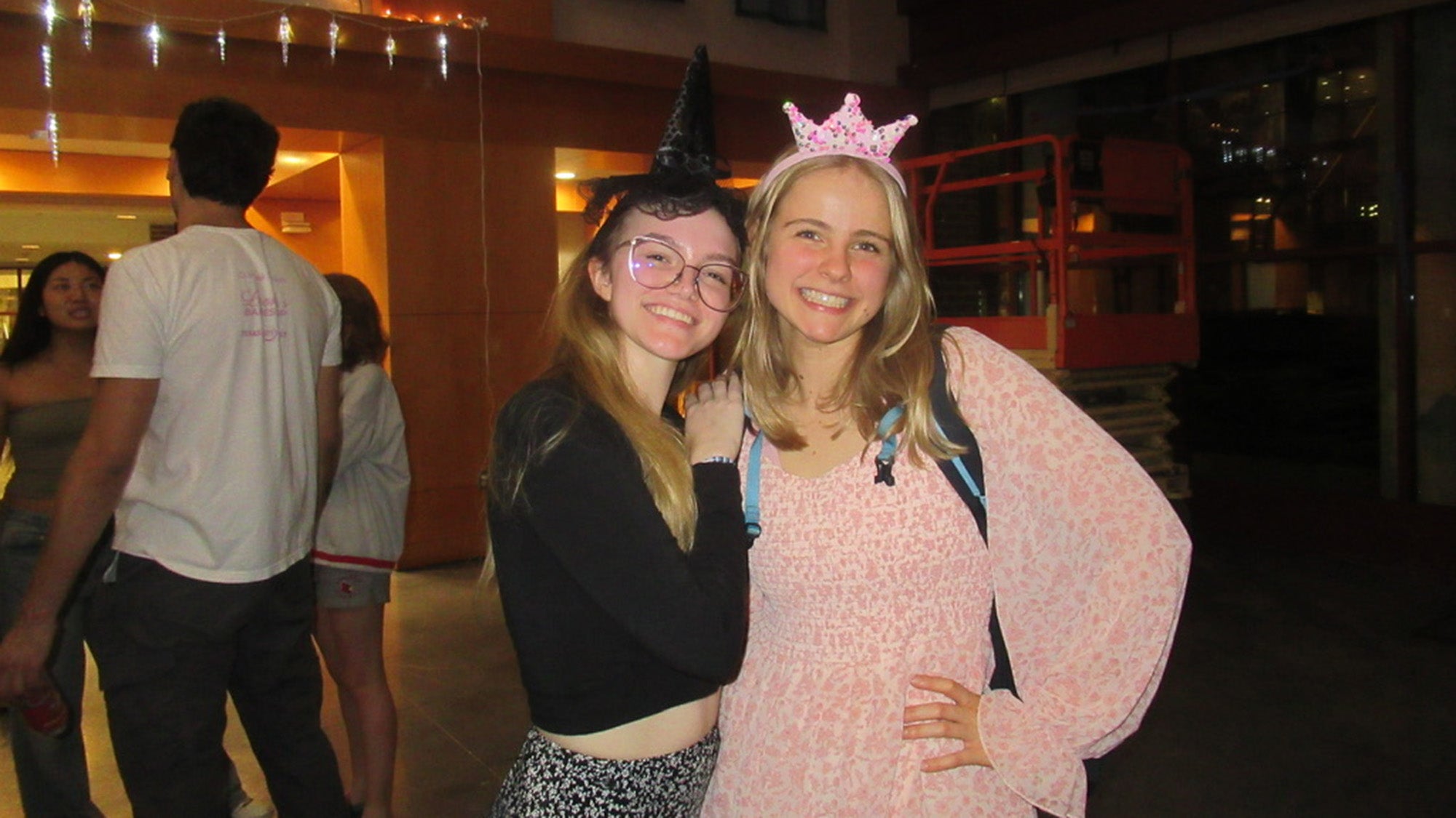 Two girls posing for a photo in black and pink colored outfits
