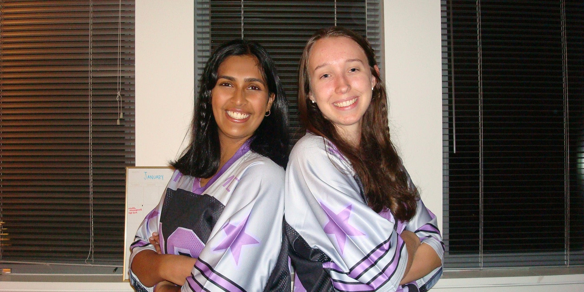 Two girls standing back-to-back with arms crossed
