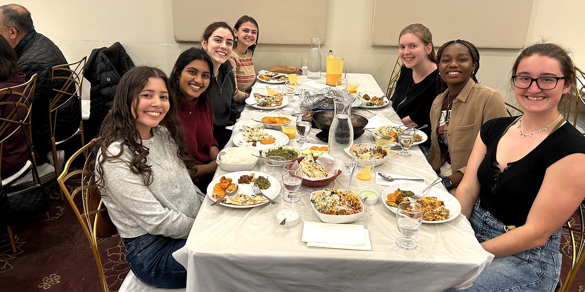 Young women seated around a white table at a restaurant