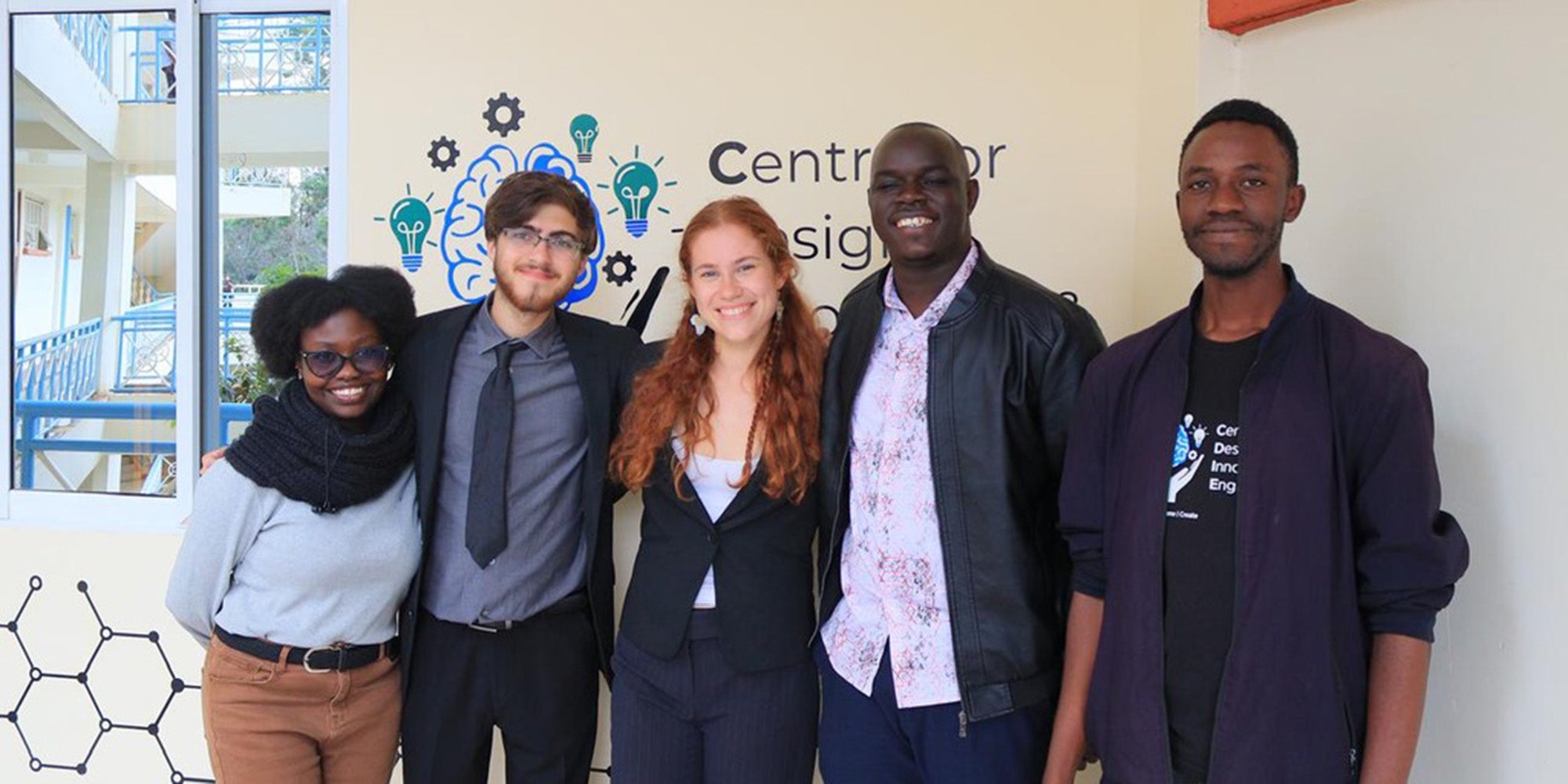 Five people standing in front of a wall 