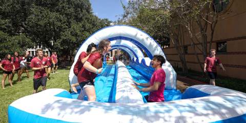 Students enjoying an O-Week slip and slide