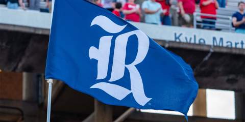 A blue flag with the Rice "R" in white waving in the football stands