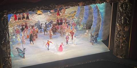 Faraway shot of the stage with dancing performers in colorful costumes.