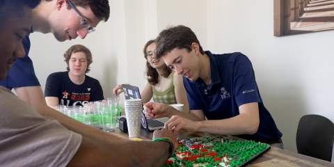 Andrew Linhart working on the LEGO Rice University build with other students.