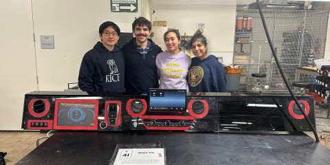 4 Rice students posing in front of a black lab table