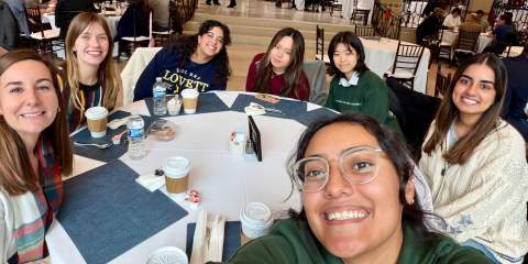 Selfie of several students around a round table