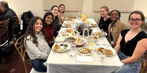 Young women seated around a white table at a restaurant