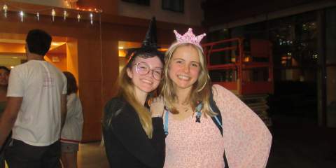 Two girls posing for a photo in black and pink colored outfits