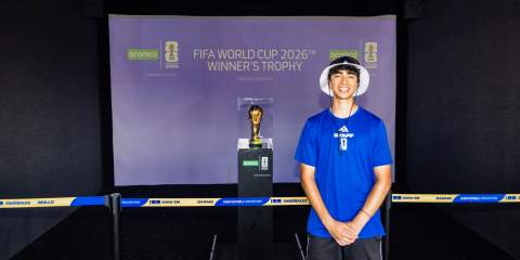 A guy standing in front of a World Cup trophy