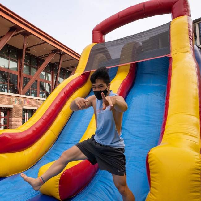 a male student slides down a water slide