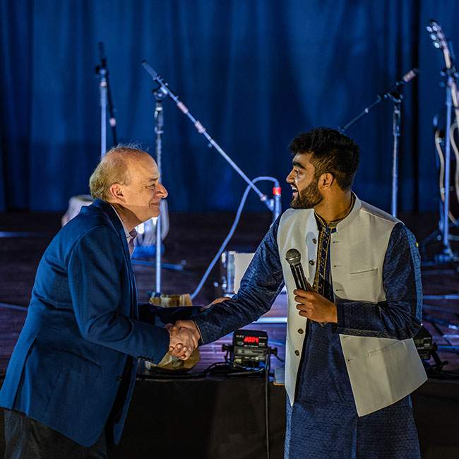 A picture of Rice's president, David Leebron, shaking the hand of Pranav Mehta, a co-president of the Rice South Asian Society.