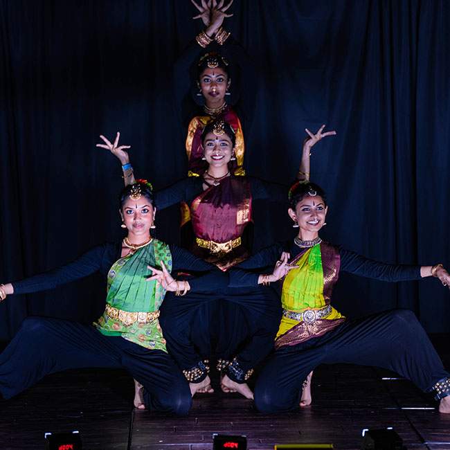 A group of four ladies dancing at Dhamaka as part of Rice Rasikas. The dance consists of Bharatanatyam, a classical dance form originating from Tamil Nadu in southern India.