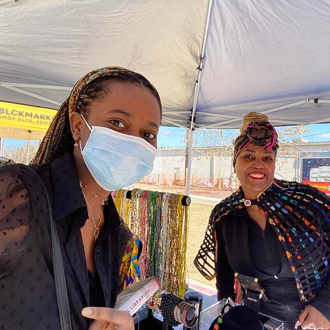 A female Rice student poses in a selfie with one of the vendors at BLCK Market Houston.