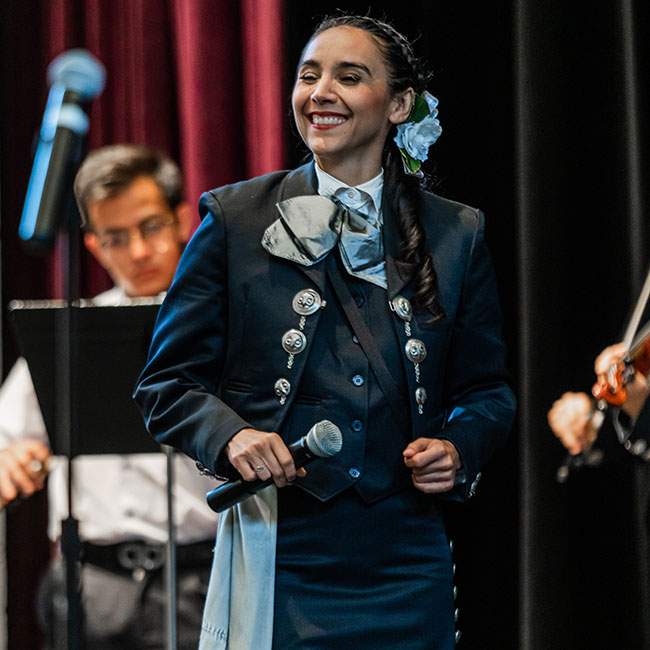 A female Rice student performs on stage with Mariachi Luna Llena, Rice's mariachi band.