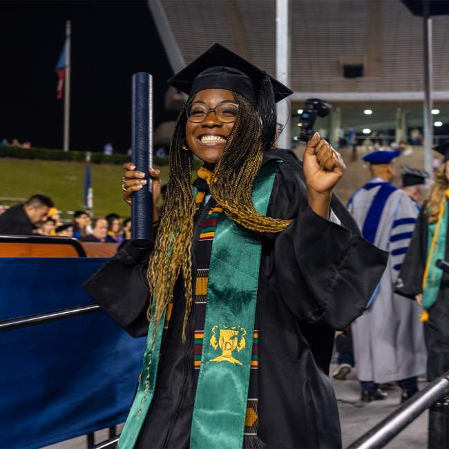 A Rice graduate celebrates with their diploma