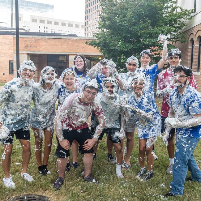 group of students covered in shaving cream posing for a photo 