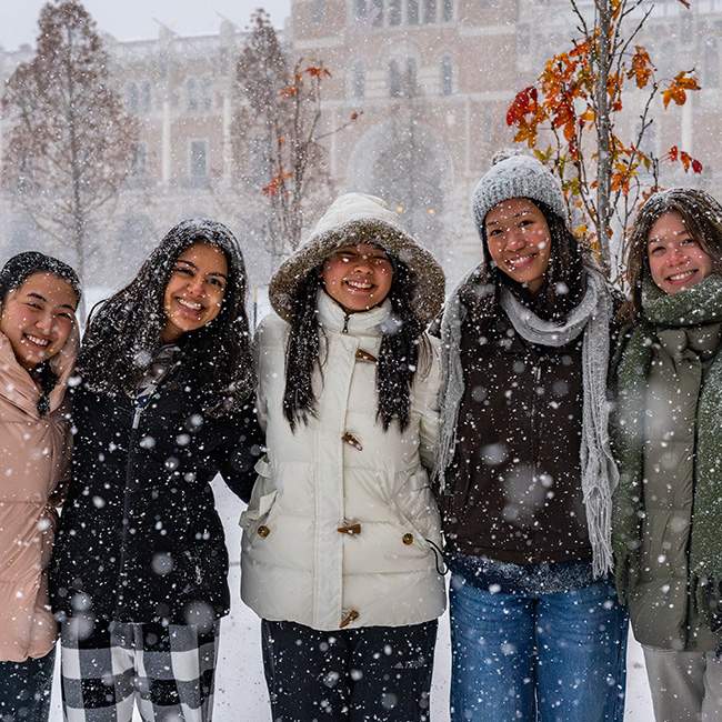 A group of college students posing in the snow 