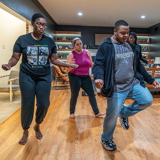 A group of 3 college students dancing