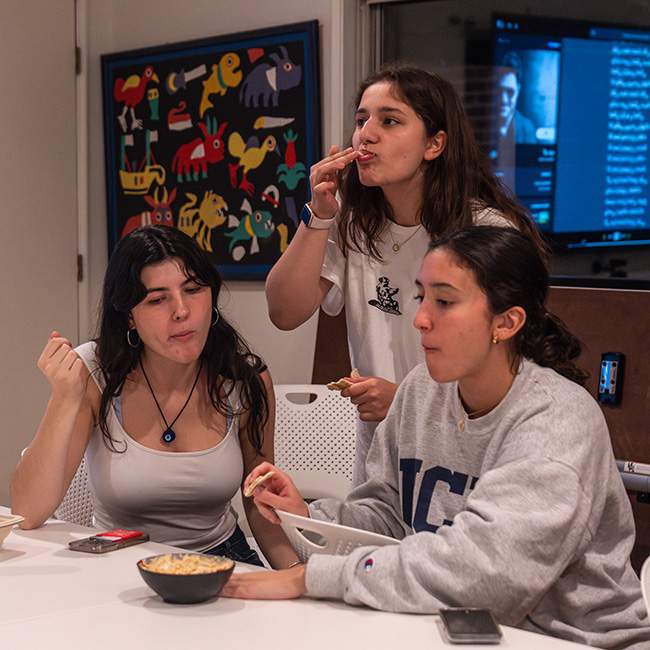 3 college age girls eating hummus together 